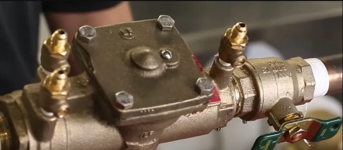 Close-up of a metal backflow preventer body and test ports during backflow preventer testing in surprise, az
