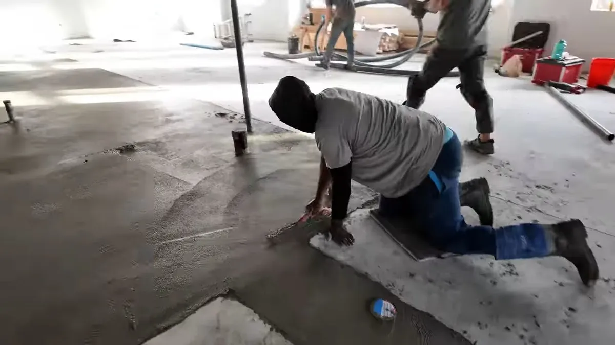 Workers laying out plumbing rough-ins across a concrete commercial floor illustrating hoa vs homeowner plumbing responsibility in surprise az