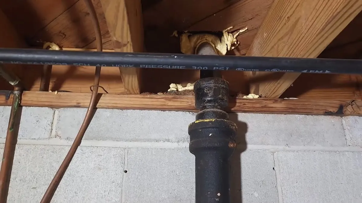 Corroded cast iron pipe section with visible rust and buildup during plumbing service in Original Surprise, AZ, with focus on scale buildup corroded pipe section