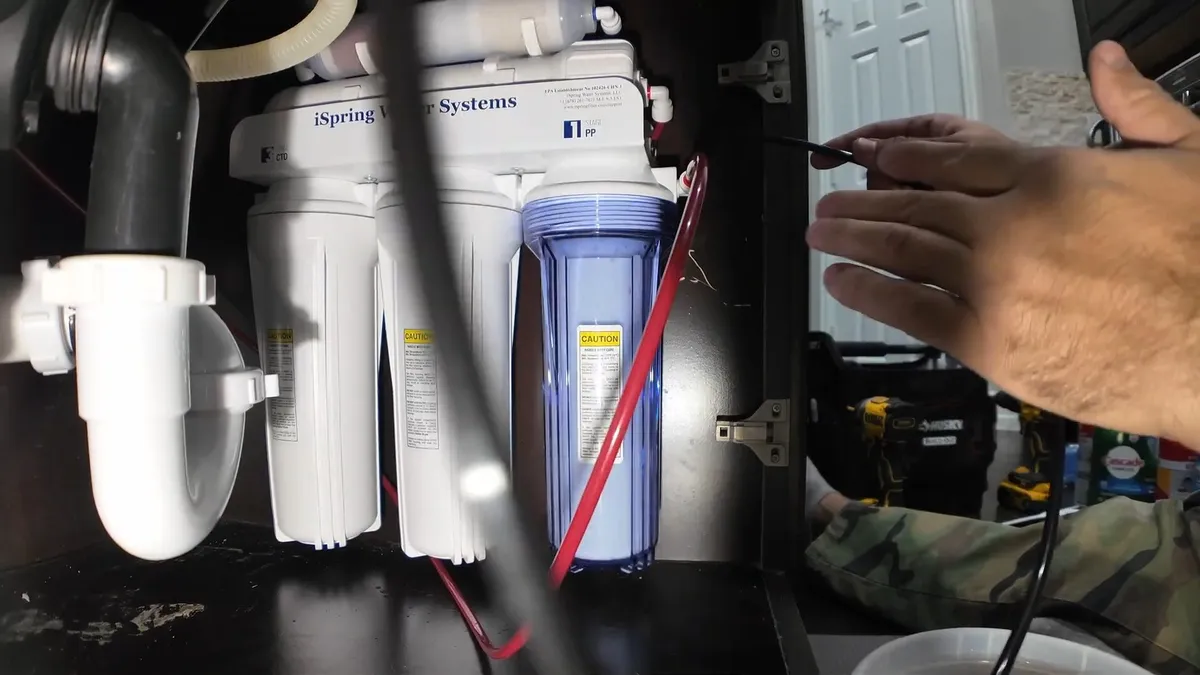 Under-sink reverse osmosis filter system connected below a cabinet during reverse osmosis installation in surprise, az, with focus on under sink reverse osmosis filter