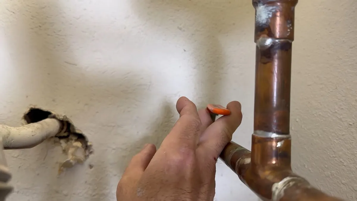 Technician marking a copper water-heater connection for service during plumbing service in Royal Ranch, Surprise, AZ