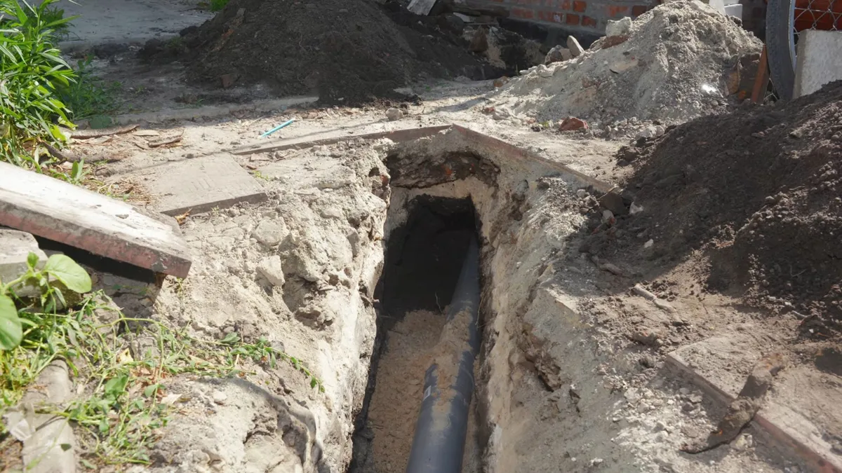 Excavated pipe repair area with exposed underground plumbing during sewer line repair in surprise, az