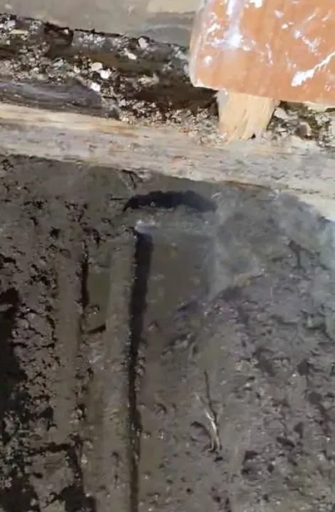 Concrete slab opening exposing a dark, wet plumbing cavity below illustrating slab leak warning signs in surprise az