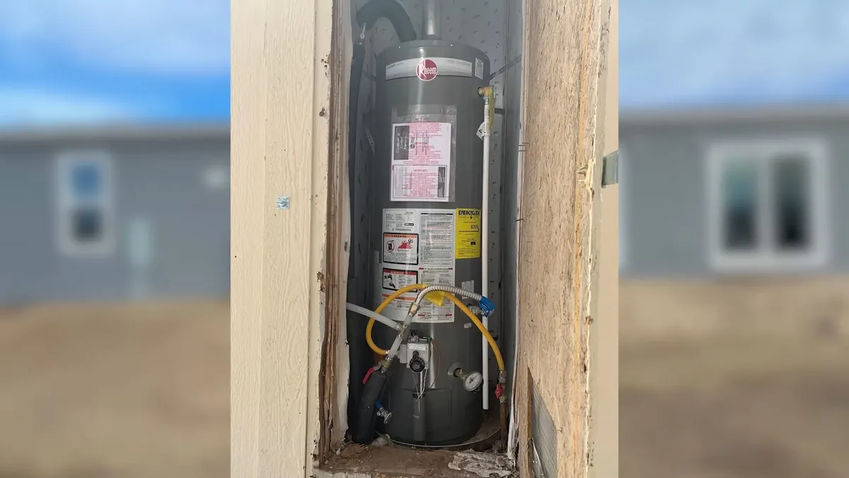 Tank water heater with nearby valves, venting, and supply connections during plumbing service in Sun City Grand, Surprise, AZ