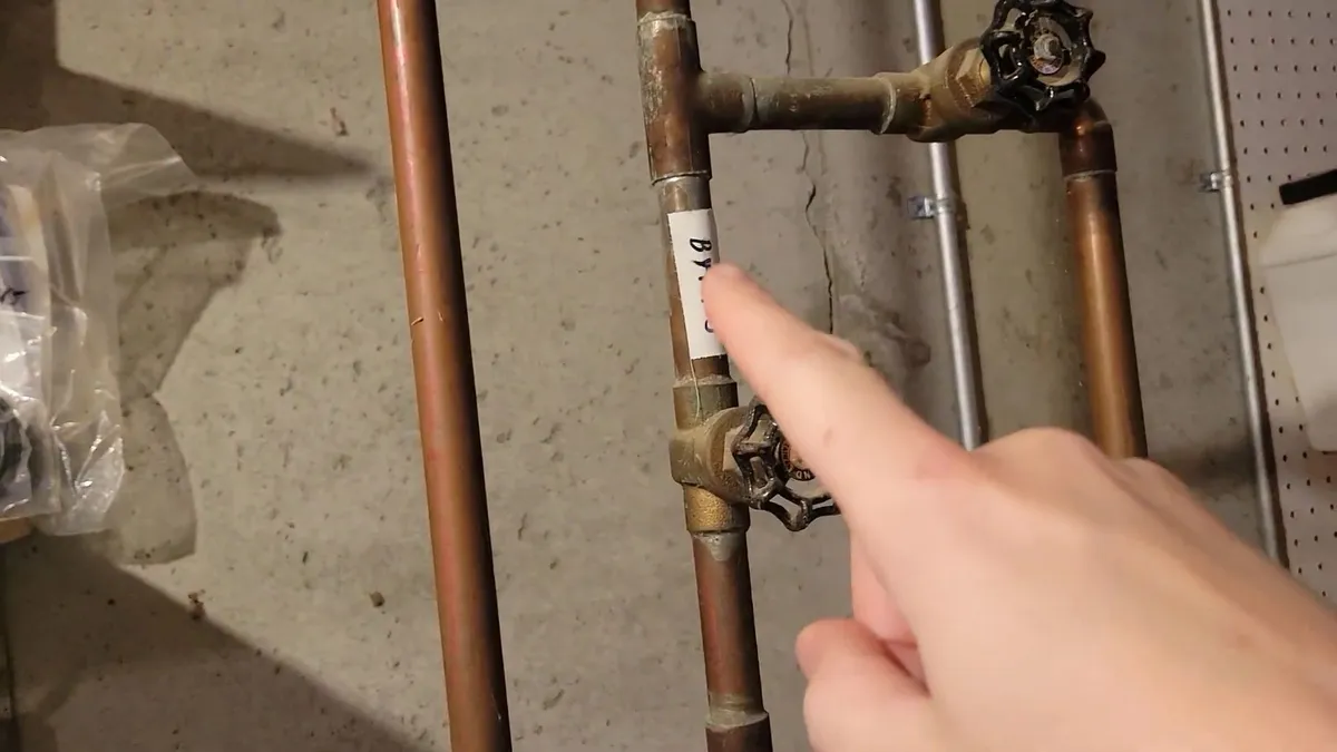 Plumber working on gas water heater piping and controls during plumbing service in Sun City