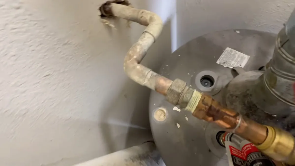 Corroded water-heater piping and fittings at the top of a tank during plumbing service in Sun City West