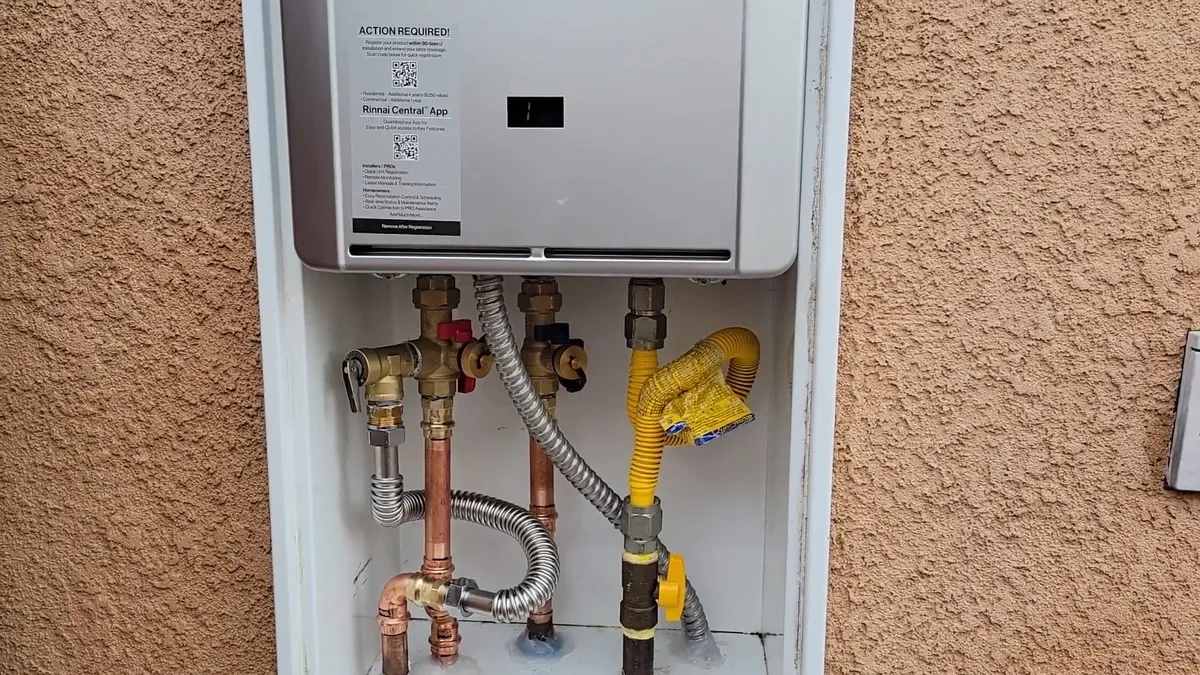 Wall-mounted tankless water heater with gas and water connections during tankless water heater installation in surprise, az