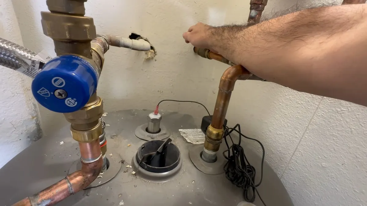 Water heater anode rod being removed for inspection illustrating water heater replacement in sun city grand az guide