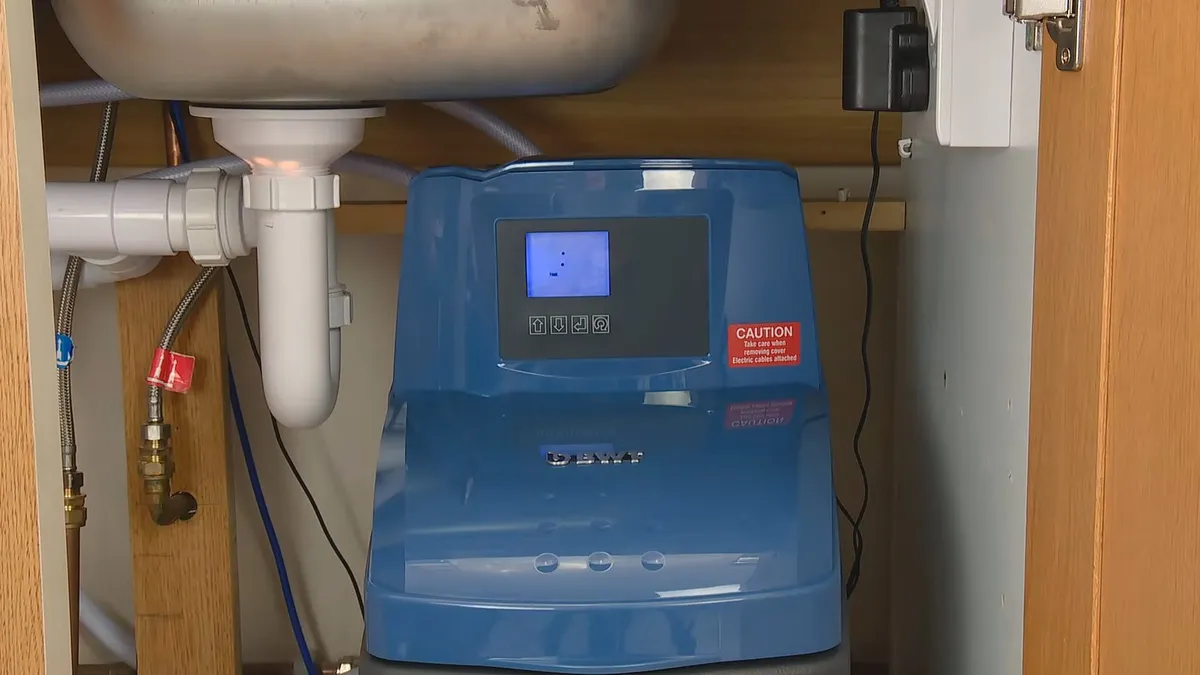 Whole-house water softener with control valve and resin tank during water softener installation in surprise, az